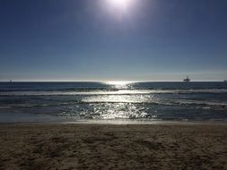 sailing ship in the distance and sun reflection in the sea at sunset