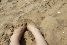 feet in the sand on the beach