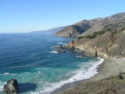 bay with grey sand beach at rocks