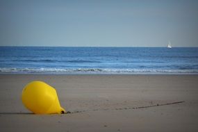 yellow buoy on the sand on the coast
