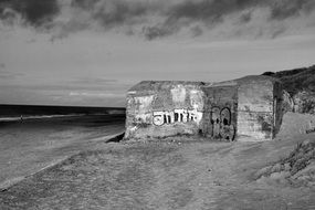 concrete bunker with graffiti on wall on beach at north sea, denmark