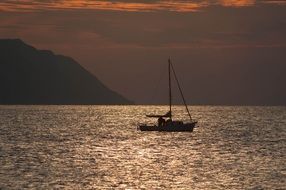 sailing boat in the ocean at sunset