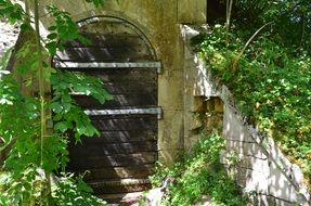 wooden door to stone fence