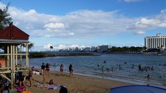 people resting on beach in front of city, puerto rico