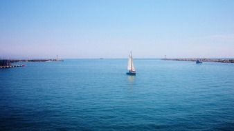 blue sailing boat on calm water