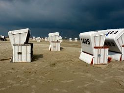 sun loungers on the beach under dark clouds