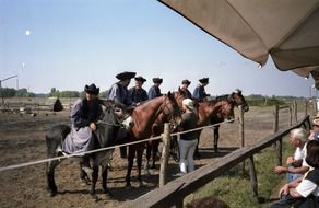horse riders in traditional hats at countryside, hungary, puszta