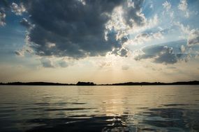 sun rays behind the clouds over the lake