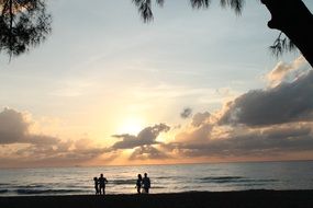 people resting on ocean beach at dusk