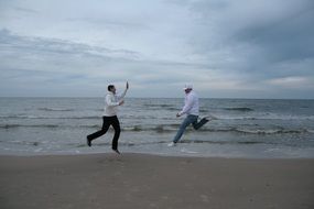 friends are jumping on the shore of the Baltic Sea