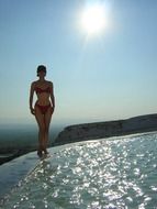young woman in bikini at glossy sea