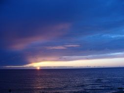 scenic blue clouds above water at sunset