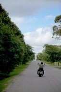 motorcyclist in helmet is riding on the road to Uruguay