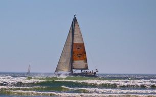 sailboat sailing in the waves of the ocean