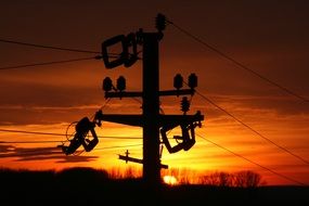 electric poles at orange sunset