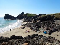 people on the beach near the rocks