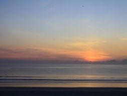 sunrise behind the clouds on the horizon of the sea