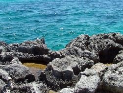 gray rocks on the background of the turquoise ocean