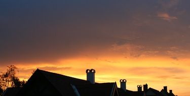 orange clouds over the roof at sunset