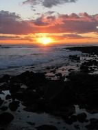 sunset on the horizon of the rocky coast