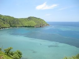 green hills near blue water
