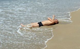 man relaxing in water by the sea