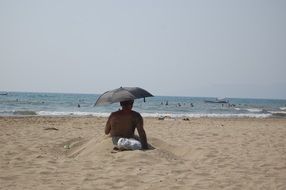 man with umbrella on a sunny beach