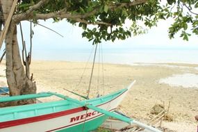turquoise fishing boat on the beach