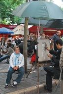 street artist paints a portrait of a boy