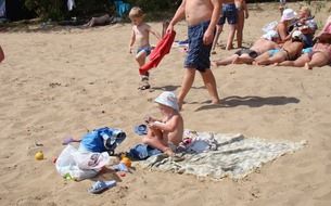child girl looking at paper on beach