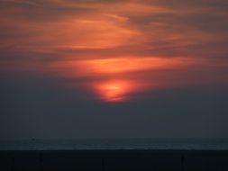 sunset behind dark clouds over the sea