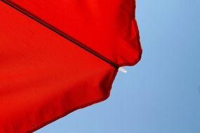 photo of red beach umbrella against blue sky