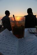 a glass on the table near the letter
