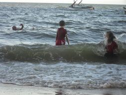 happy kids in the surf of the ocean