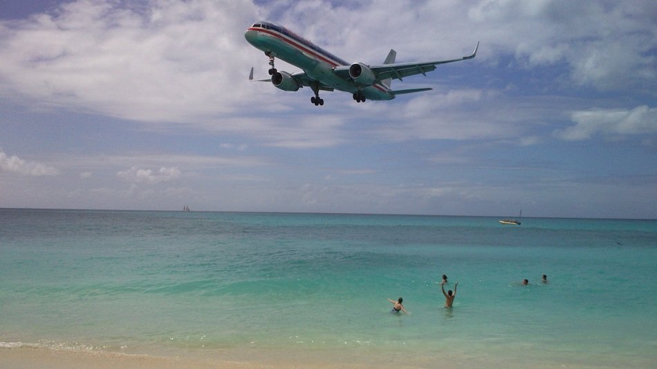 the plane flies over the beach in the Caribbean