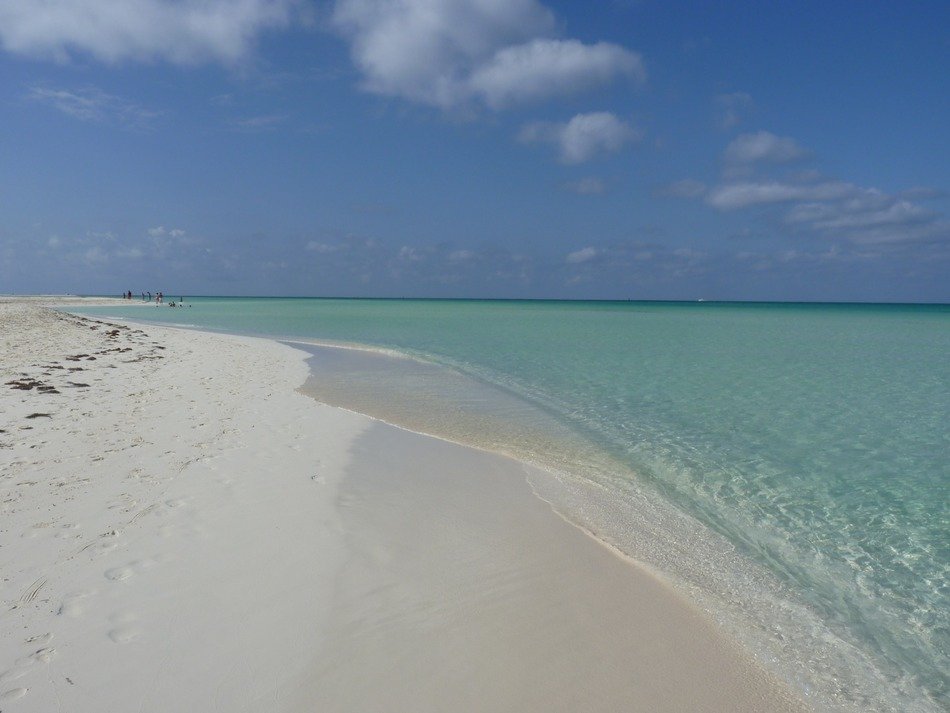 blue water on the white sand of the beach