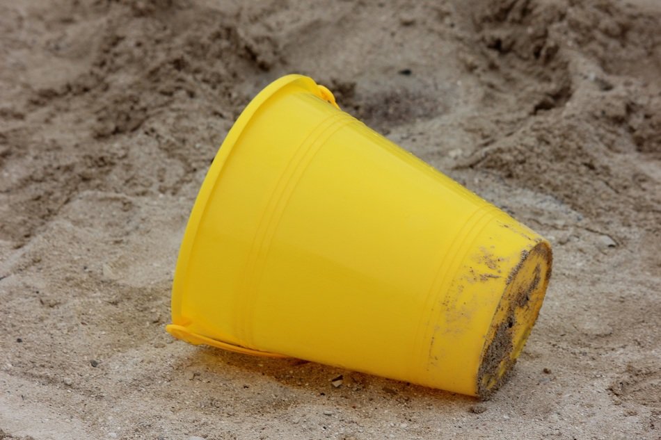 yellow plastic bucket on the beach