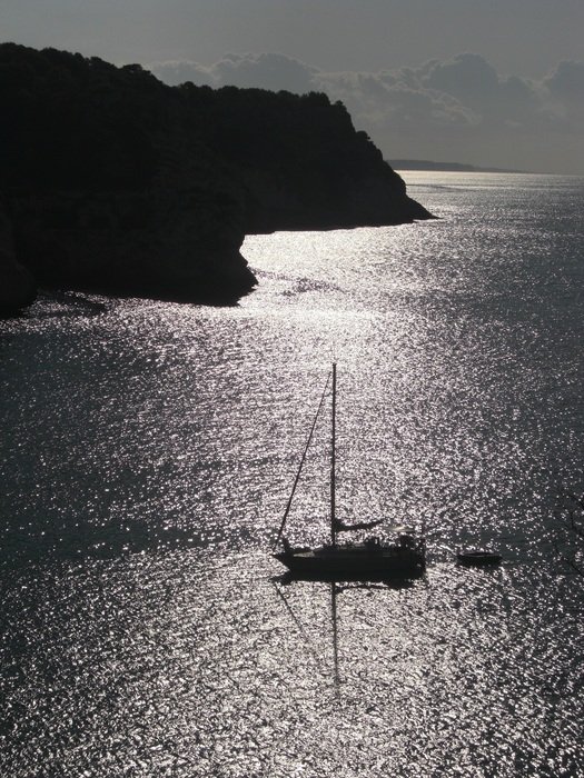 boat on the water near the rocks at dusk