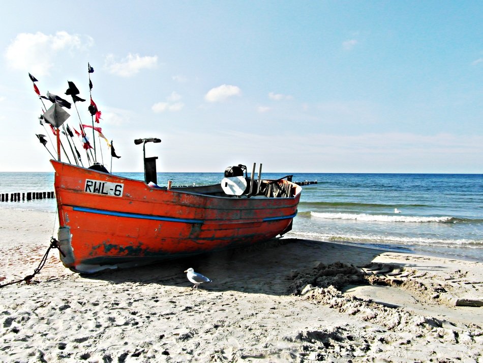 Red and blue cutter on the sandy sea beach