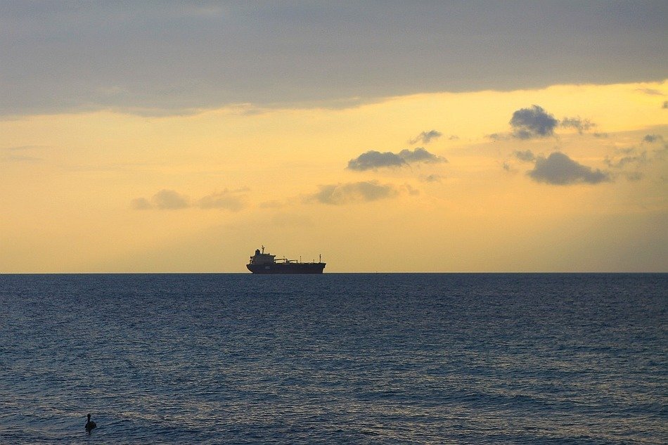 cargo ship on the horizon in the sunset