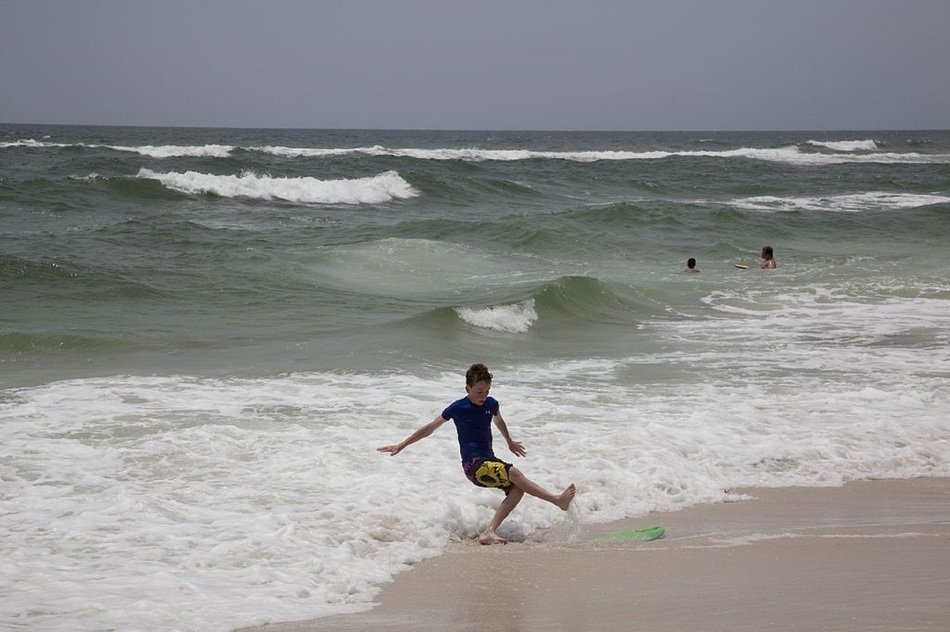 child plays with waves on the beach