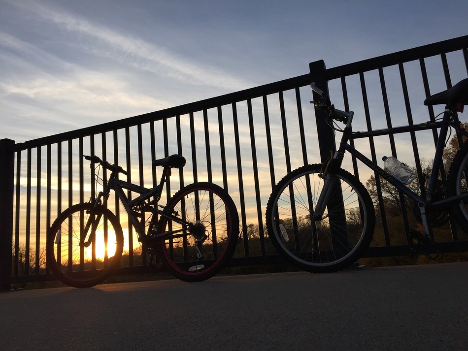 bicycles at the fence in the light of sunset
