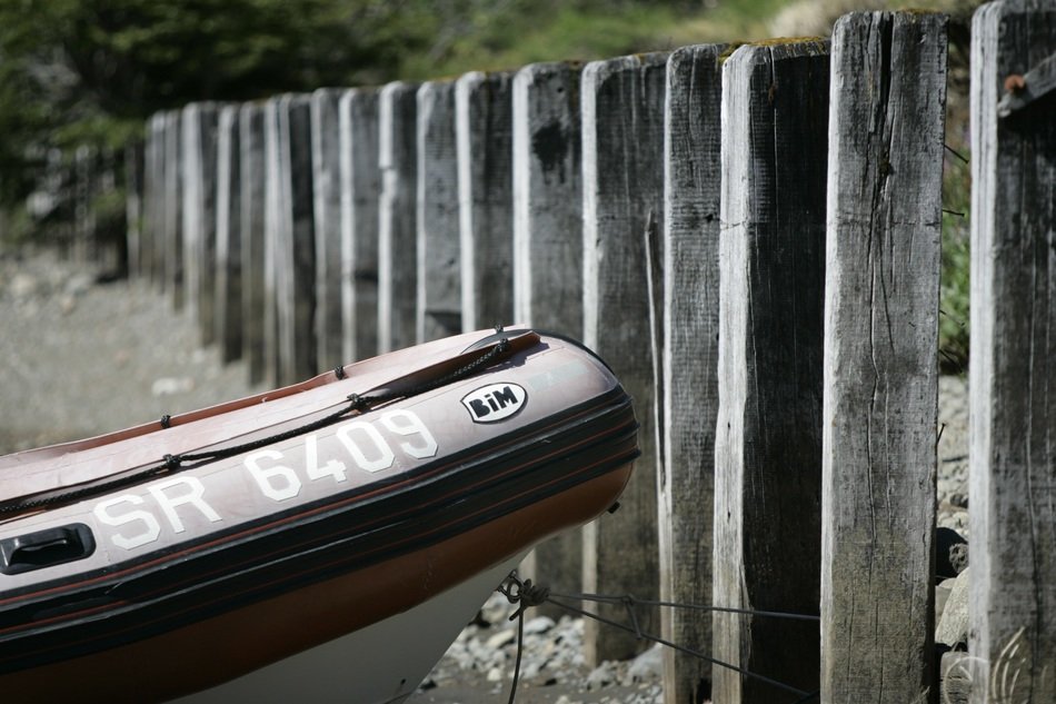 bow of boat at row of wooden pillars