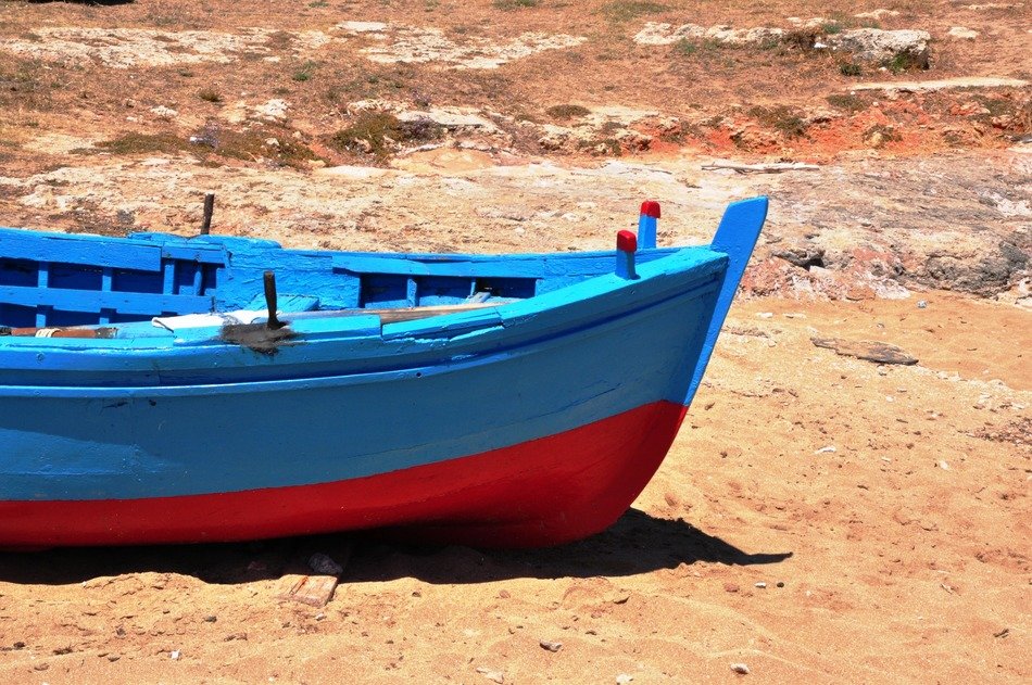 blue and red boat on sand