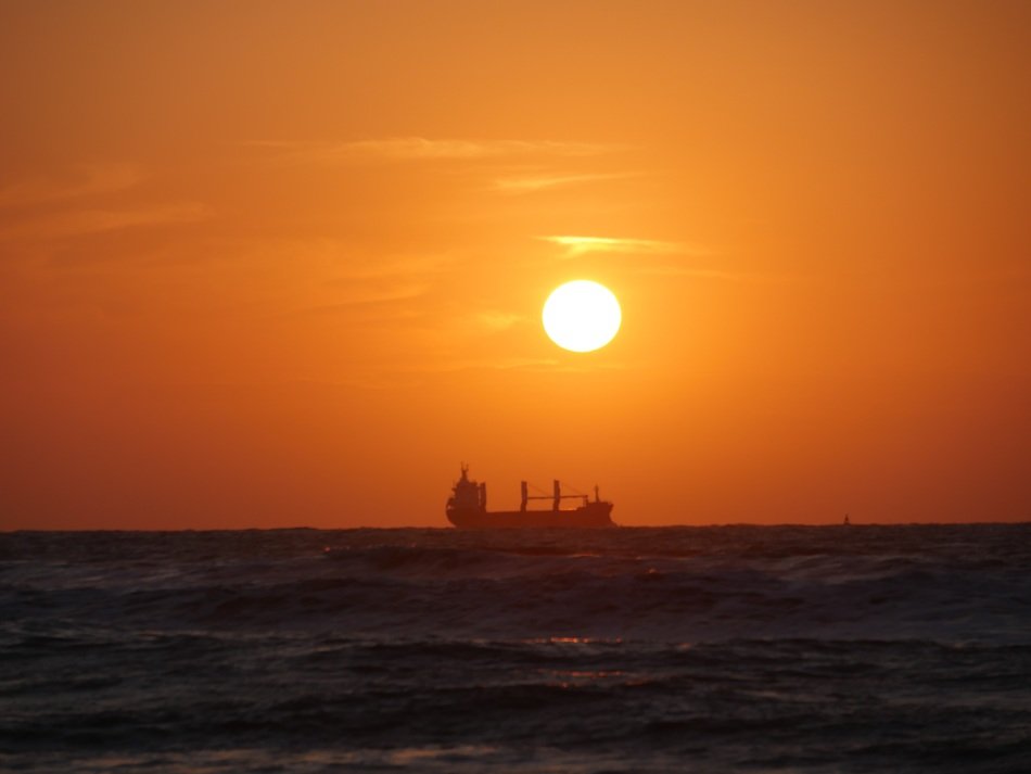 ship at sea on a background of golden sunset