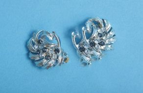 silver earrings on a blue background