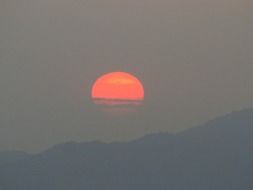 red sun above the mountains on the horizon