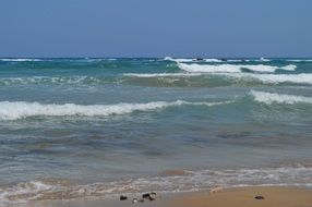 Sandy beach with the waves in the water