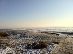 snowy beach at frozen water, winter landscape