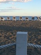 beach with sun loungers at sunset